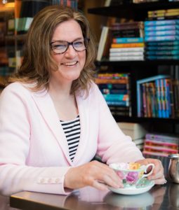 author smiling drinking tea