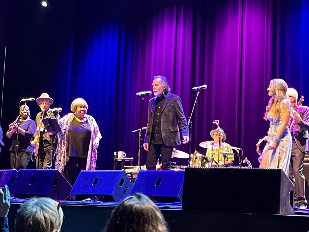 Concert stage with Mavis Staples, Jackson Browne, and Margo Price and band on stage together.