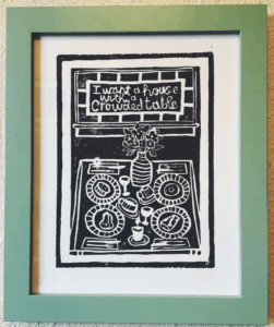 A linoprint of “I want a house with a crowded table” from VatnInk on Etsy. These are lyrics from the song “Crowded Table” by the Highwomen. 